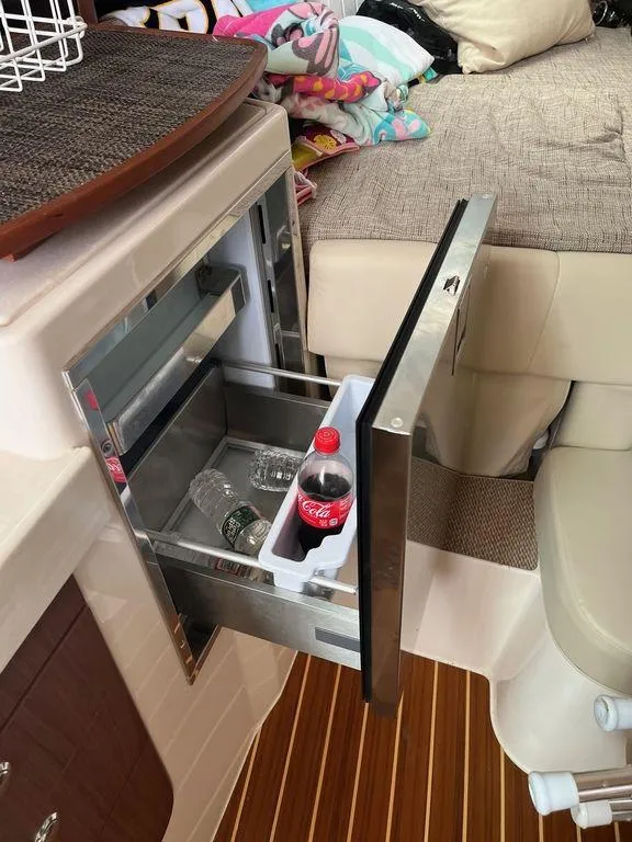 Slide: The Image of Grady-White 330 Express 2020 interior with open mini fridge and seating area. - 12