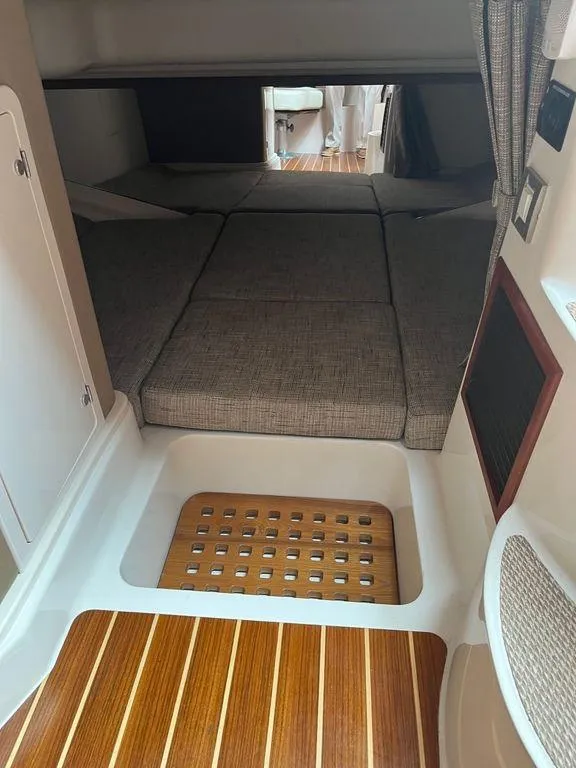 Slide: The Image of 2020 Grady-White 330 Express cabin interior with wooden flooring and cushioned seating. - 14