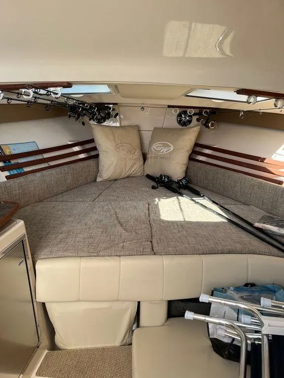 Slide: The Image of 2020 Grady-White 330 Express cabin interior with fishing rods and cushions. - 17