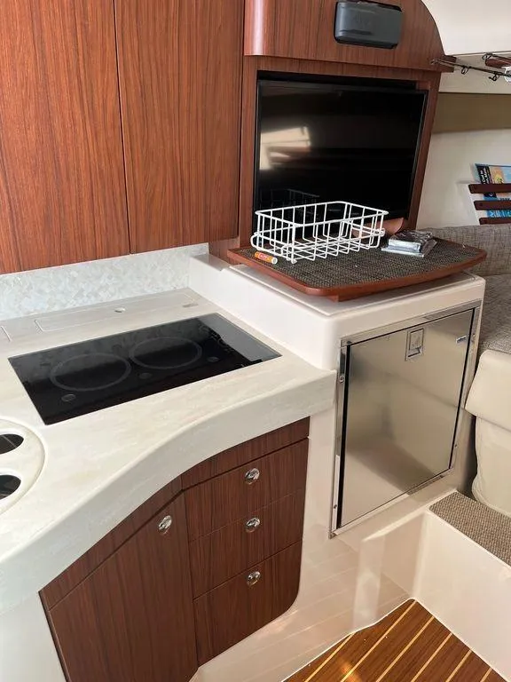 Slide: The Image of 2020 Grady-White 330 Express yacht interior with kitchenette and TV. - 18