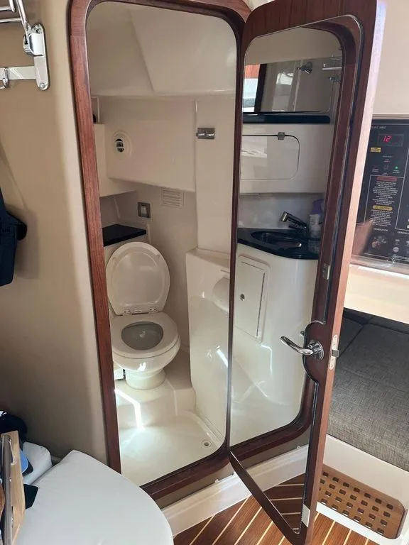 Slide: The Image of 2020 Grady-White 330 Express boat interior bathroom with toilet and sink. - 19