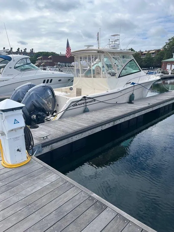 Slide: The Image of 2020 Grady-White 330 Express boat docked at marina with twin outboard engines. - 5