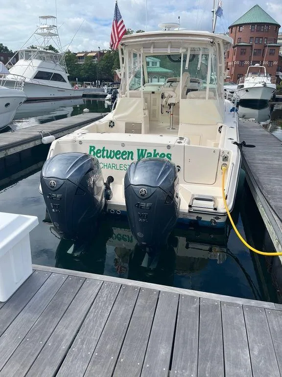 Slide: The Image of 2020 Grady-White 330 Express boat docked with twin outboard engines. - 8