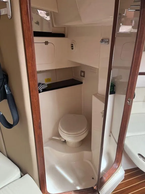 Slide: The Image of 2020 Grady-White 330 Express boat bathroom with toilet and storage compartments. - 9