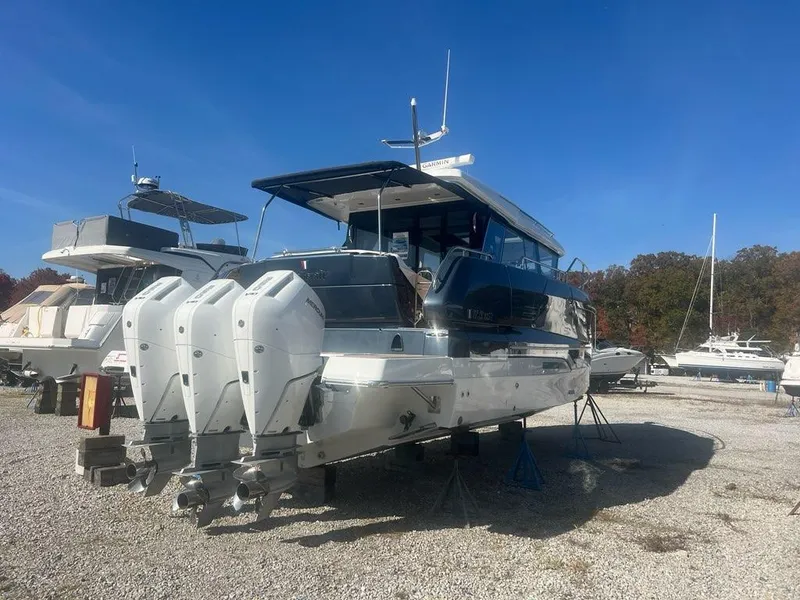 Slide: The Image of 2025 Wellcraft 44 Explorer yacht with triple outboard engines on a gravel lot. - 2