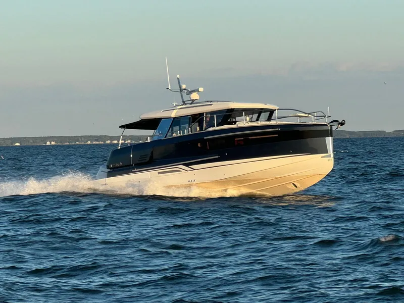 Slide: The Image of 2025 Wellcraft 44 Explorer yacht cruising on open water at sunset. - 4