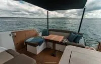 Slide: The Image of 2025 Wellcraft 44 Explorer boat interior with seating and table, overlooking the ocean. - 6
