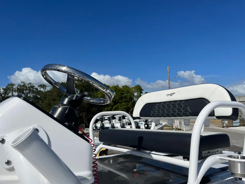 Slide: The Image of 2025 Tidewater 2500 Carolina Bay boat helm and seating under clear blue sky. - 12