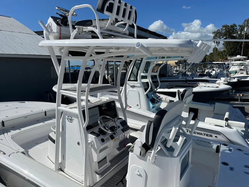 Slide: The Image of 2025 Tidewater 2500 Carolina Bay boat with dual consoles and T-top in a marina. - 5