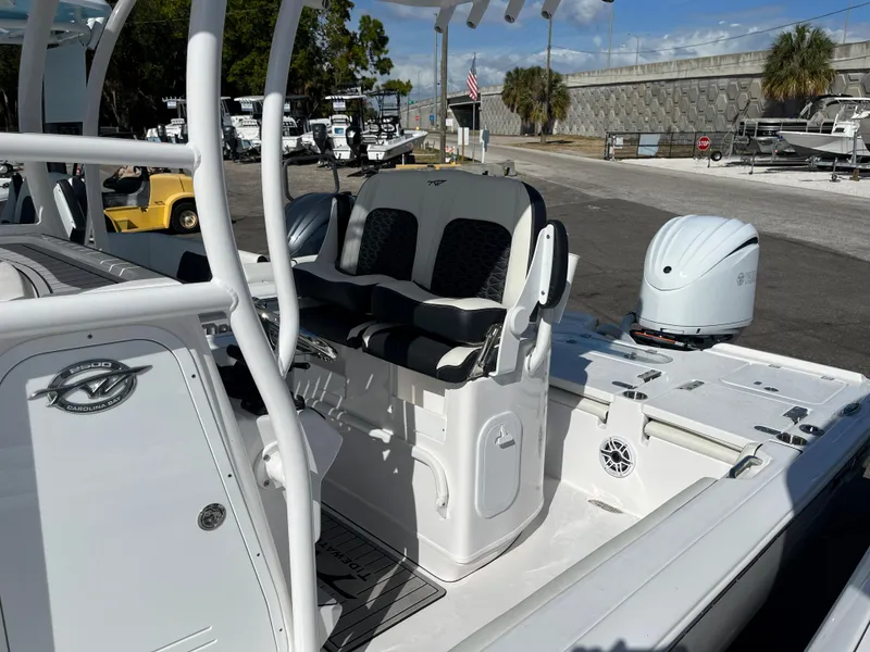 Slide: The Image of 2025 Tidewater 2500 Carolina Bay boat interior with seating and outboard motor. - 9
