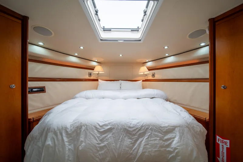 Slide: The Image of Luxurious bedroom in a 2009 Bertram 630 yacht with skylight and cozy bedding. - 27