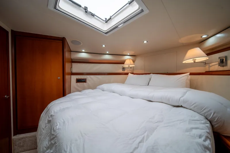 Slide: The Image of Luxurious bedroom interior of a 2009 Bertram 630 yacht with skylight and cozy bedding. - 28