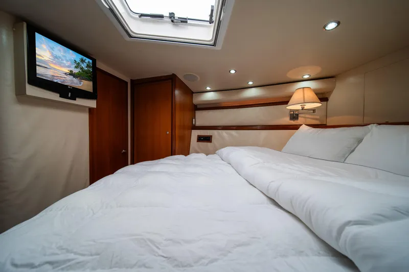 Slide: The Image of Luxurious bedroom in a 2009 Bertram 630 yacht with TV and skylight. - 29