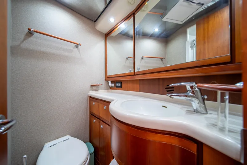 Slide: The Image of Luxurious bathroom in a 2009 Bertram 630 yacht with wooden cabinetry and modern fixtures. - 30