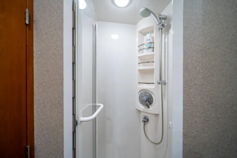 Slide: The Image of Shower area in a 2009 Bertram 630 yacht with modern fixtures and built-in shelves. - 31