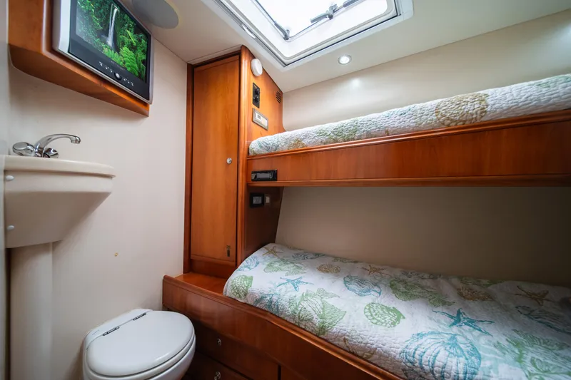 Slide: The Image of Interior cabin of 2009 Bertram 630 yacht with bunk beds, TV, sink, and toilet. - 32