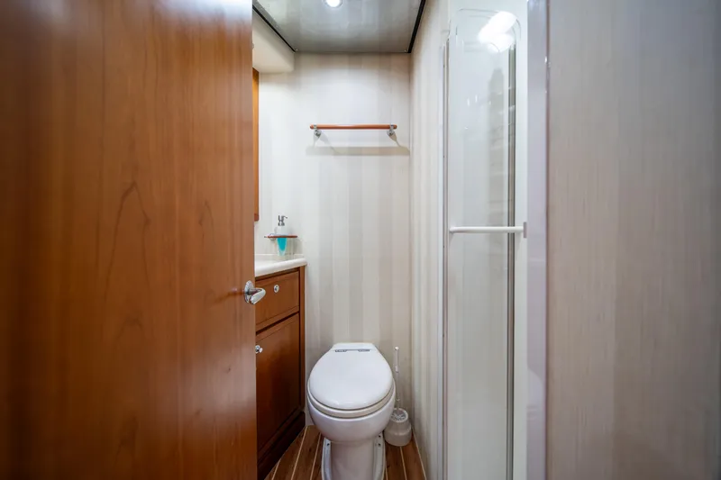 Slide: The Image of Compact bathroom in a 2009 Bertram 630 yacht with wooden cabinetry and shower. - 37