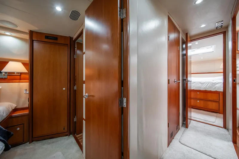 Slide: The Image of Interior of 2009 Bertram 630 yacht with wooden doors and cozy bedroom. - 41