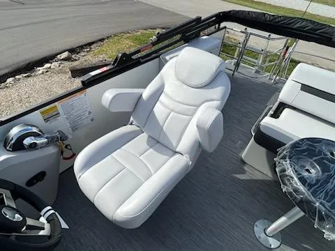 Slide: The Image of 2024 Sweetwater 2286SFL boat interior with white captain's chair and steering wheel. - 8