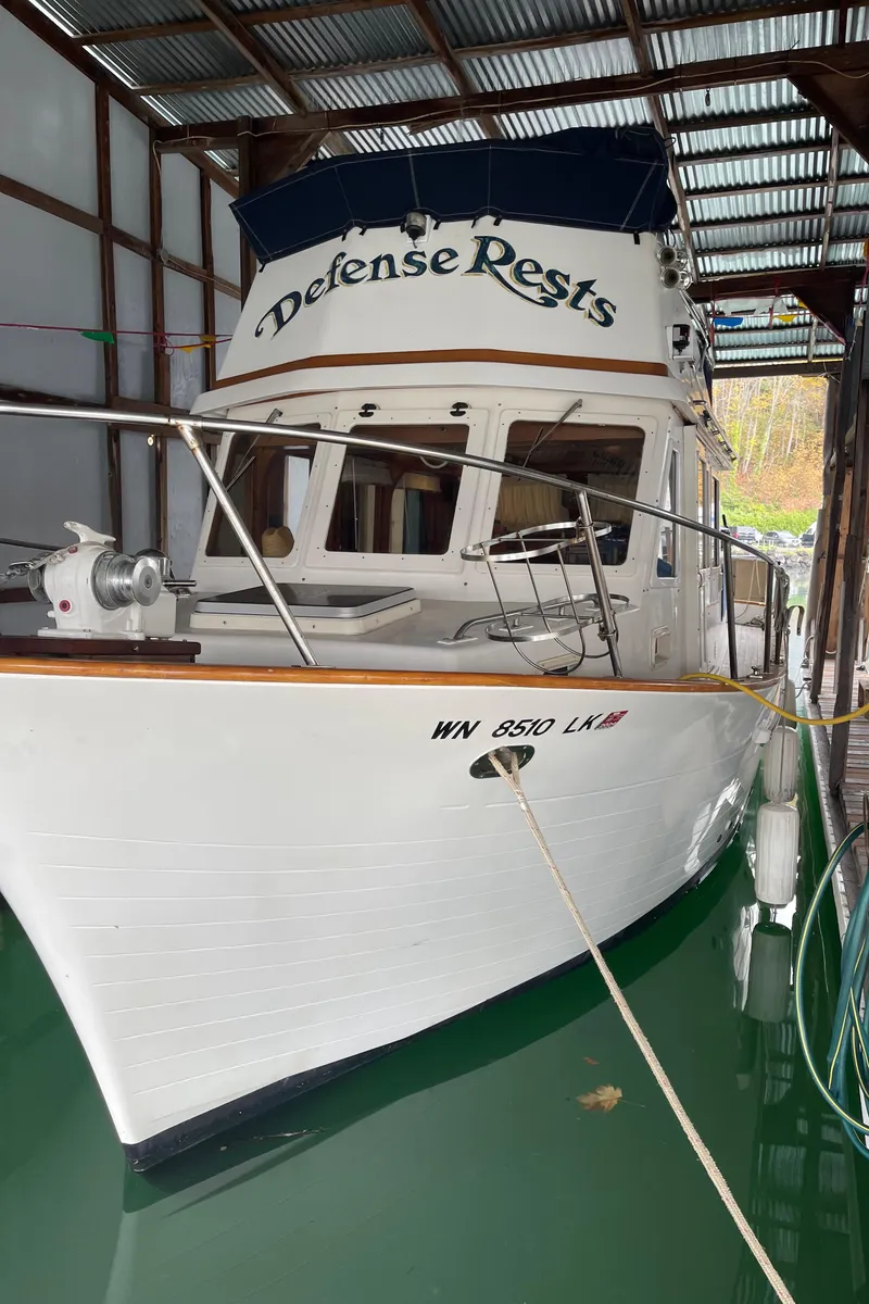 The Image of 1984 CHB 35 boat named Defense Rests docked in a covered marina. - 0
