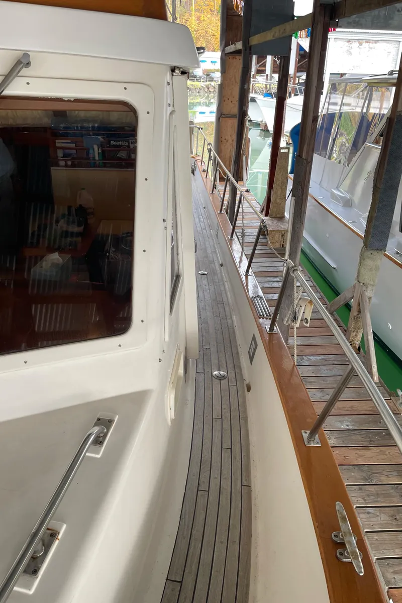 Slide: The Image of 1984 CHB 35 boat docked, side view with wooden deck and railing. - 24