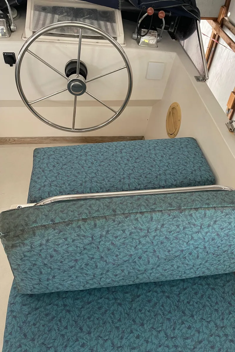 Slide: The Image of Interior of 1984 CHB 35 boat with steering wheel and blue cushioned seating. - 8