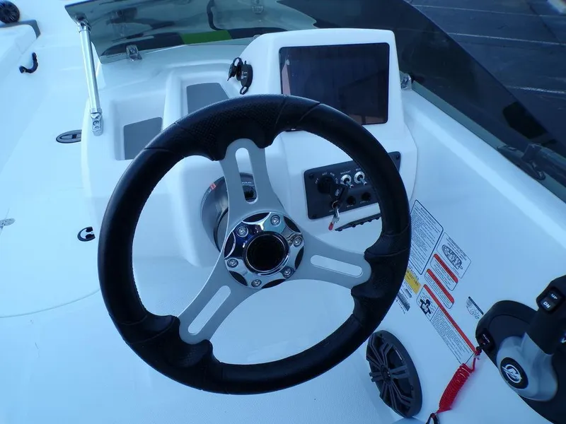 Slide: The Image of 2024 Tahoe T18 boat steering wheel and dashboard controls. - 15