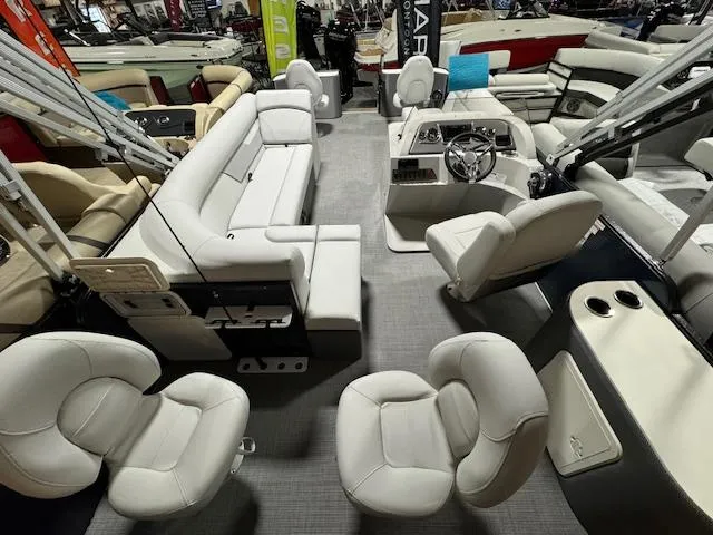 Slide: The Image of 2024 Crest Classic LX 200 C4 pontoon boat interior with white seating and modern helm. - 3