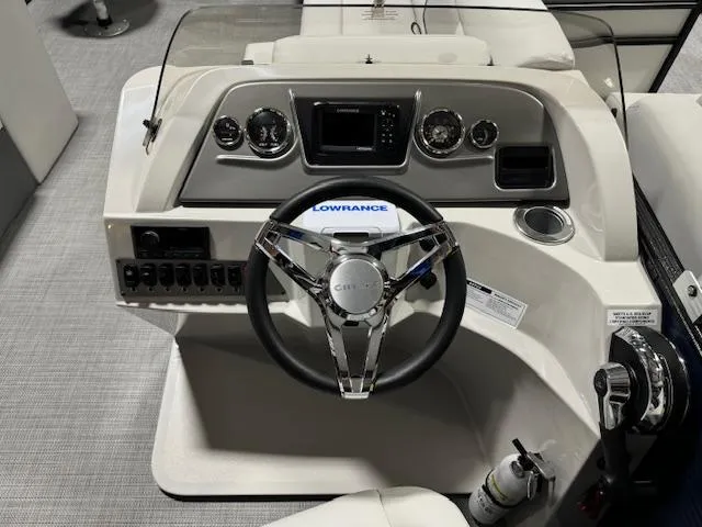 Slide: The Image of 2024 Crest Classic LX 200 C4 boat dashboard with steering wheel and control panel. - 9