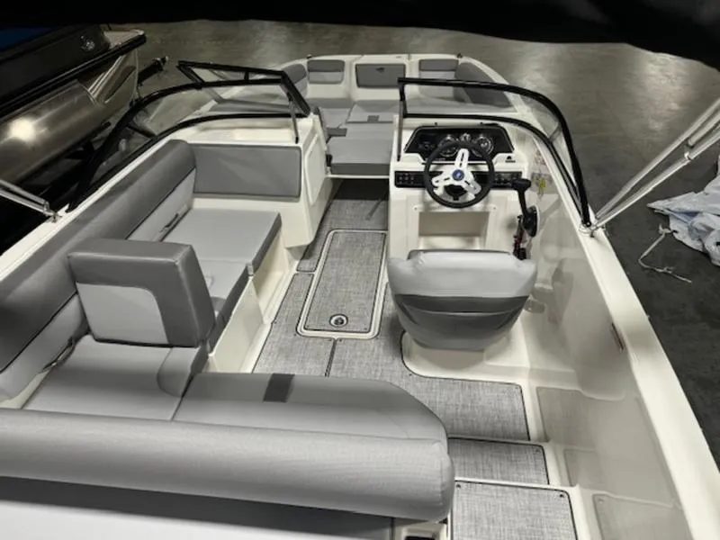 Slide: The Image of 2024 Bayliner DX 2000 boat interior with gray seating and modern dashboard. - 11