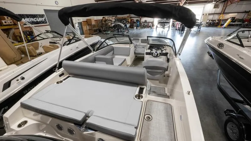 Slide: The Image of 2024 Bayliner DX 2000 boat interior with seating and steering wheel in showroom. - 12