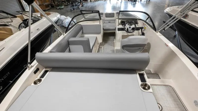 Slide: The Image of 2024 Bayliner DX 2000 boat interior with gray seating and modern dashboard. - 13