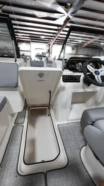 Slide: The Image of 2024 Bayliner DX 2000 interior with open storage compartment and modern dashboard. - 15