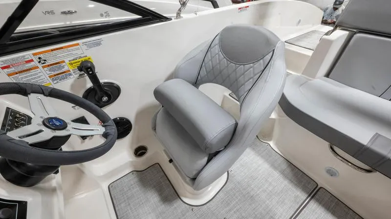 Slide: The Image of 2024 Bayliner DX 2000 boat interior with steering wheel and cushioned captain's chair. - 17