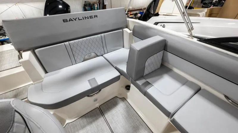 Slide: The Image of 2024 Bayliner DX 2000 boat interior with gray cushioned seating and modern design. - 18