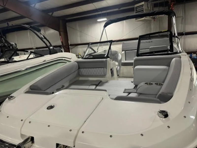 Slide: The Image of 2024 Bayliner DX 2000 boat interior with gray seating in a showroom. - 22