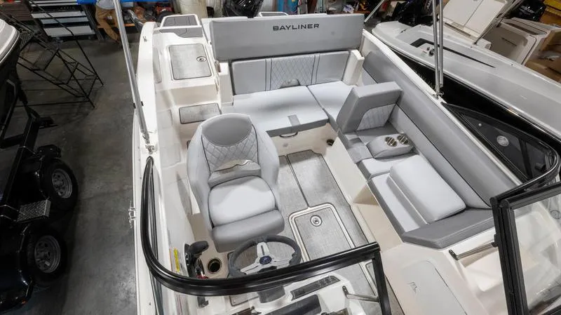 Slide: The Image of 2024 Bayliner DX 2000 boat interior with seating and steering wheel, showcasing modern design. - 28