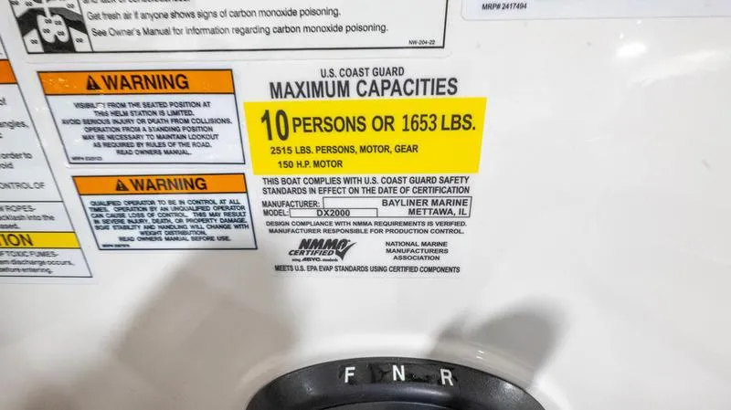 Slide: The Image of 2024 Bayliner DX 2000 capacity label, 10 persons or 1653 lbs, safety warnings visible. - 31
