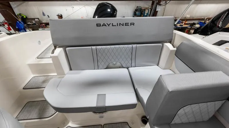 Slide: The Image of 2024 Bayliner DX 2000 boat interior with gray seating and Bayliner branding. - 4
