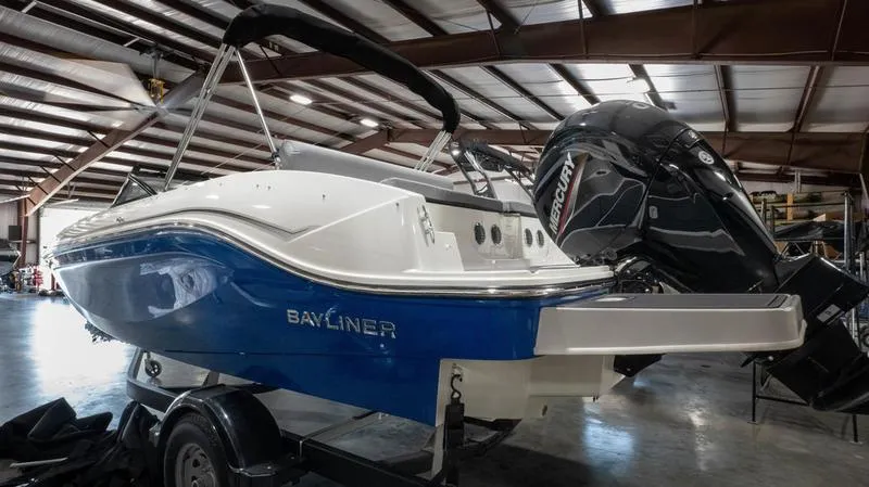 Slide: The Image of 2024 Bayliner DX 2000 boat with Mercury engine in a warehouse setting. - 6