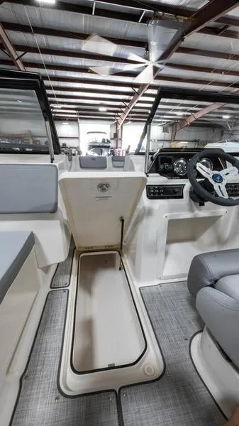 Slide: The Image of 2024 Bayliner DX 2000 boat interior with modern dashboard and seating. - 9