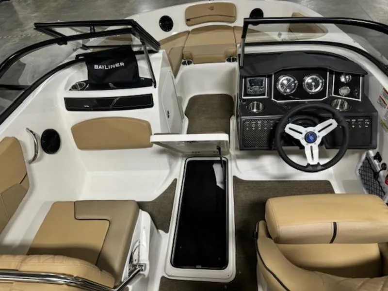 Slide: The Image of 2024 Bayliner VR5 Bowrider Outboard interior with tan and white seating, steering console, and storage. - 3
