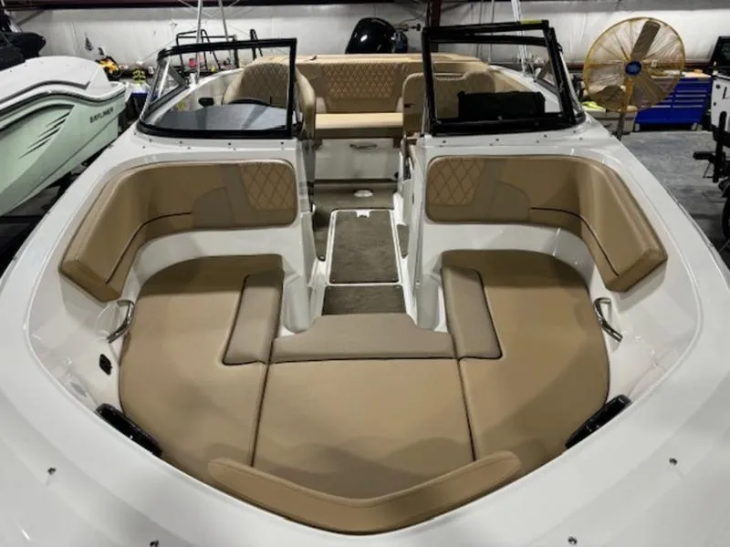 Slide: The Image of 2024 Bayliner VR5 Bowrider Outboard with spacious tan seating in a showroom. - 7