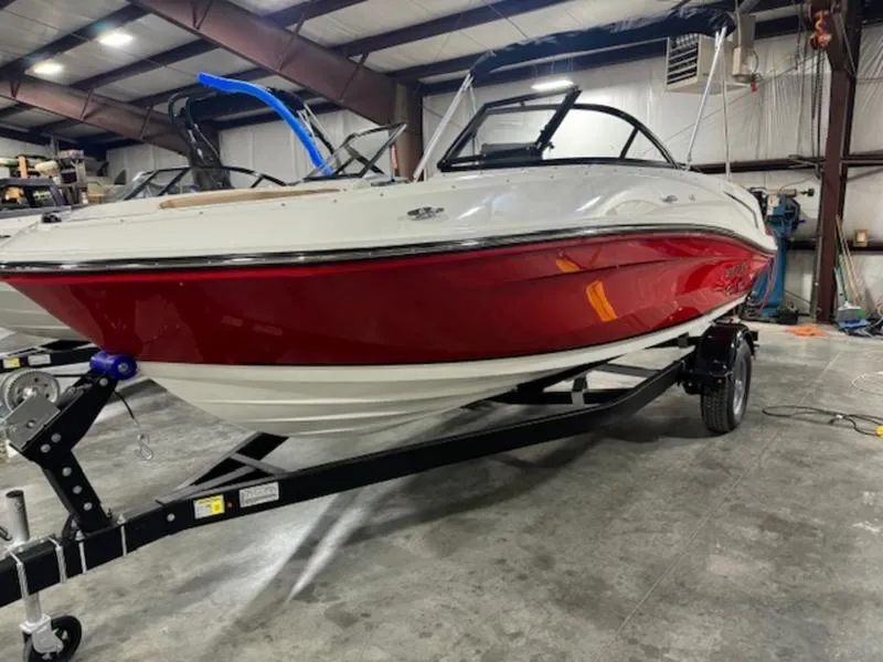 Slide: The Image of 2024 Bayliner VR5 Bowrider Outboard in a warehouse, red and white hull on a trailer. - 8