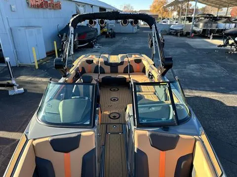 Slide: The Image of 2024 MasterCraft XT24 boat with tan and black interior, docked at a marina. - 17