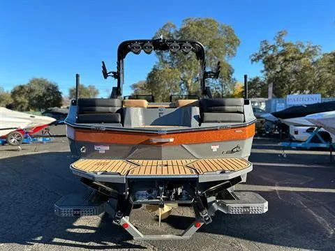 Slide: The Image of 2024 MasterCraft XT24 boat rear view with teak swim platform. - 2
