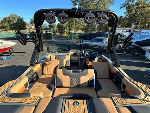 Slide: The Image of 2024 MasterCraft XT24 boat interior with tan and black seating, advanced sound system. - 9
