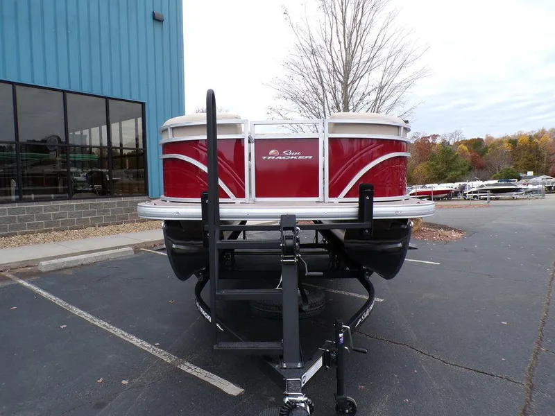 Slide: The Image of 2024 Sun Tracker PARTY BARGE® 20 DLX pontoon boat on a trailer in a parking lot. - 10