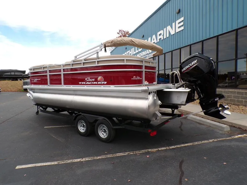 Slide: The Image of 2024 Sun Tracker PARTY BARGE® 20 DLX pontoon boat on trailer outside marine dealership. - 3