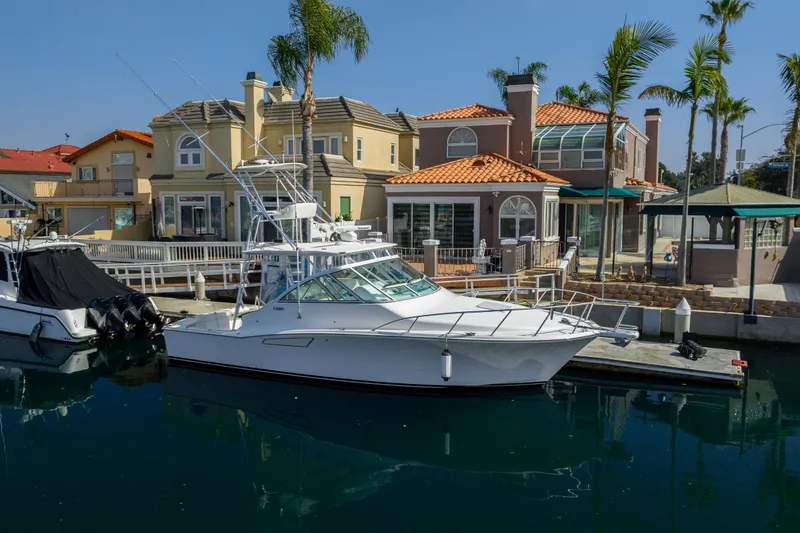 The Image of 2013 Cabo 36 Express yacht docked near waterfront homes. - 0